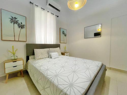 um quarto com uma cama grande e um edredão branco em Oasis Inn em San Juan