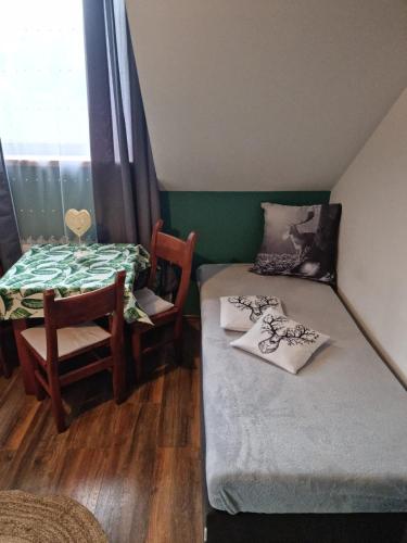 a room with a bed and a table and a chair at Ostoja Karkonoska in Podgórzyn