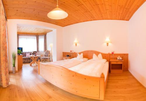 a large wooden bed in a bedroom with a wooden ceiling at Hotel Christoph in Neustift im Stubaital