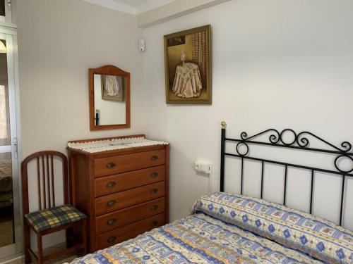 een slaapkamer met een bed, een dressoir en een spiegel bij TRUJILLO CUÉNTAME -Apartamento bien equipado, de fácil aparcamiento y acceso-Ideal punto de partida de sus rutas in Trujillo