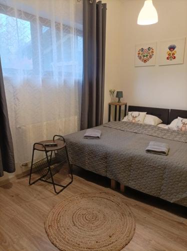 a bedroom with a bed and a window and a rug at Ostoja Karkonoska in Podgórzyn