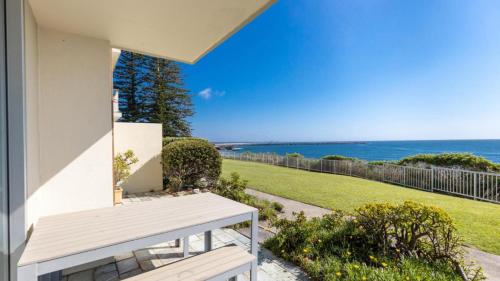 a white bench sitting on the side of a house at Craigmore on the Beach unit 6 in Yamba