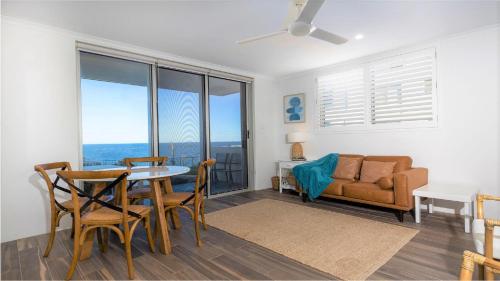 a living room with a table and chairs and a couch at Craigmore on the Beach unit 6 in Yamba