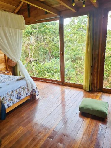 1 dormitorio con cama y ventana grande en Sweet Home in Amazon Region, en Puyo