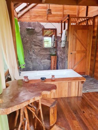 bañera en una habitación con pared de piedra en Sweet Home in Amazon Region, en Puyo