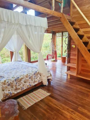 1 dormitorio con 1 cama con dosel en Sweet Home in Amazon Region, en Puyo