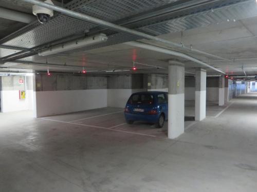 a parking garage with a small blue car parked in it at Komodo short stay apartments in Trento