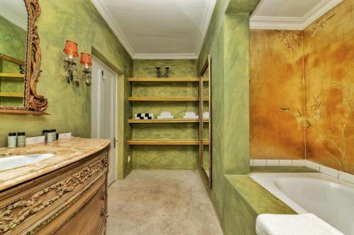 een badkamer met een bad en een wastafel bij Amina Boutique Hotel in Kaapstad