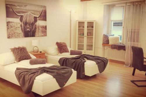 um quarto com duas camas e uma foto de uma vaca em La Suite em Chur