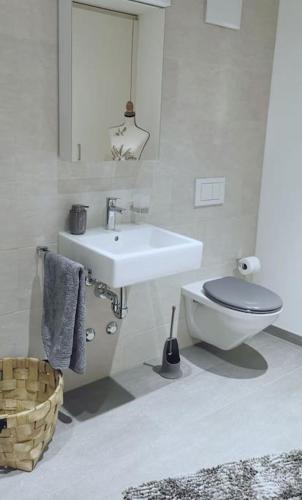 a white bathroom with a toilet and a sink at La Suite in Chur