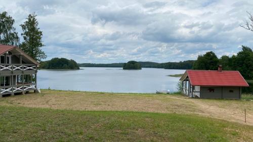 a view of a lake with a house at Kaimo turizmo sodyba „Šerno slėnis“ in Vėdariai