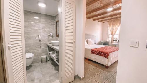 a bedroom with a bed and a bathroom with a shower at Museum Resort Spa in Bodrum City