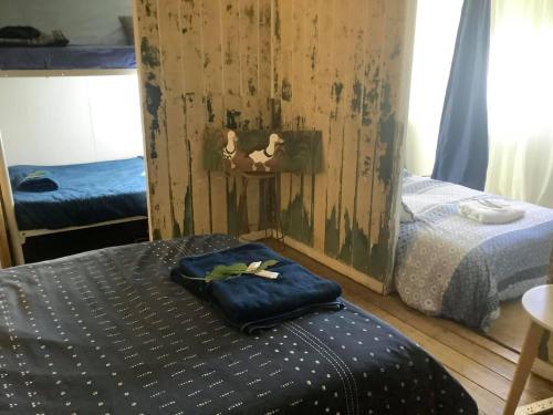 a bedroom with two twin beds and a wall with wood at Corella Creek Country Farm Stay in Nelia