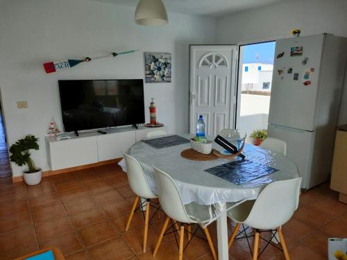 Caleta de CaballoにあるEslanzarote Los Alisios House, Super wifi, Sea viewsのダイニングルーム(テーブル、椅子、テレビ付)