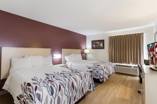 a hotel room with two beds and a flat screen tv at Red Roof Inn London I-75 in London