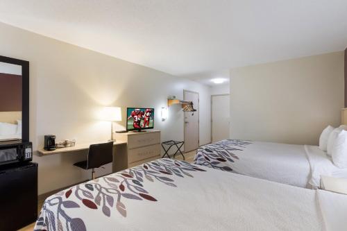 a hotel room with a bed and a desk at Red Roof Inn London I-75 in London