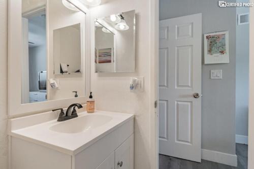 a white bathroom with a sink and a mirror at Beautiful 4 bd Mini-Farm Home in Simi with Hot Tub, One Full Bath and One Half Bath in Simi Valley