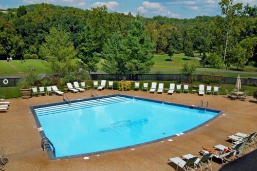a large swimming pool with lounge chairs at Couples Condo Retreat Overlooking Golf Course in Branson West