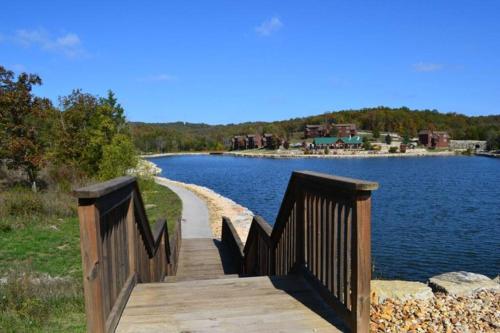 a wooden bridge over a body of water at Couples Condo Retreat Overlooking Golf Course in Branson West