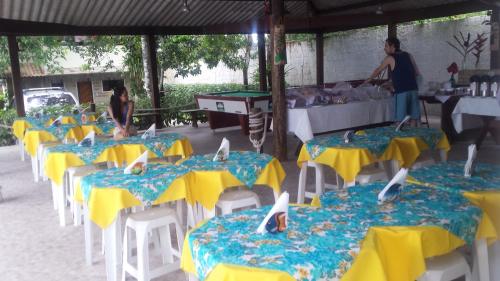 eine Gruppe von Tischen und Stühlen mit blauen und gelben Tischen in der Unterkunft Chalés Do Sol in Boracéia