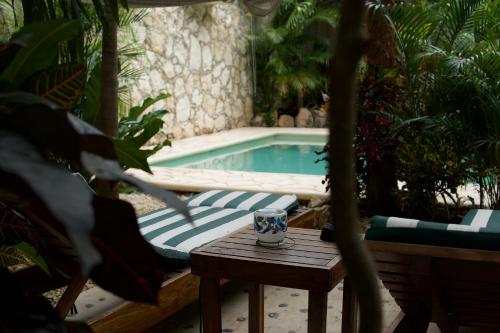 a pool with a table and chairs and a table sidx sidx sidx at Aldea San Lam - Oasis Of Tulum in Tulum