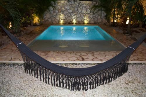 a hammock in front of a swimming pool at Aldea San Lam - Oasis Of Tulum in Tulum
