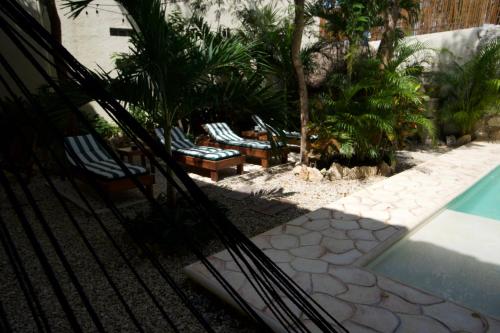 a group of chairs sitting next to a swimming pool at Aldea San Lam - Oasis Of Tulum in Tulum