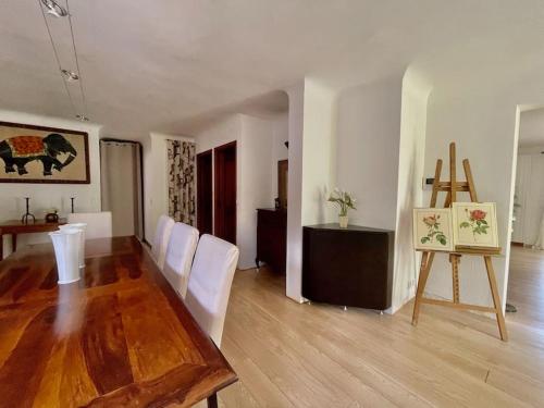 a living room with a wooden table and white chairs at Charming Villa Saint-Jean-Cap-Ferrat in Saint-Jean-Cap-Ferrat