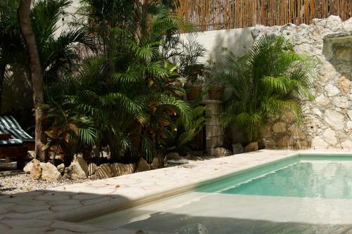 a swimming pool in a yard with palm trees at Aldea San Lam - Oasis Of Tulum in Tulum