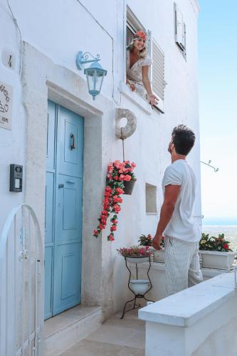 a man looking out the window of a building at BELLE HOME OSTUNI vasca vista mare in Ostuni
