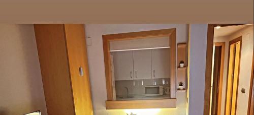 La cuisine est équipée d'un miroir et d'un four micro-ondes. dans l'établissement Airport Madrid suites apartments Belfast 13, à Madrid
