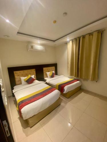 une chambre avec deux lits et une fenêtre dans l'établissement Taleen Riyadh Residential Units, à Riyad
