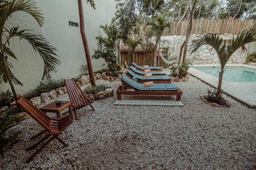 un patio con tumbonas y una piscina en Aldea San Lam - Oasis Of Tulum, en Tulum