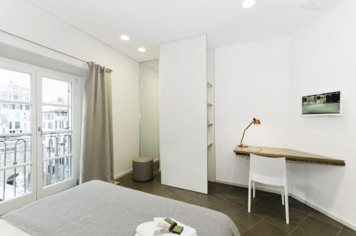 a bedroom with a bed and a desk and a window at Genova Porto Antico Boutique Rooms in Genoa