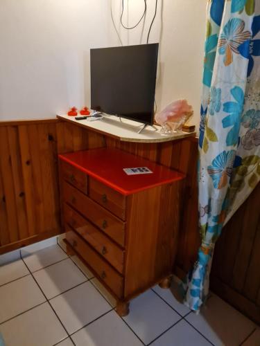 - une commode en bois avec un ordinateur portable dans l'établissement Chez Gisèle et Philippe, à Terre-de-Haut