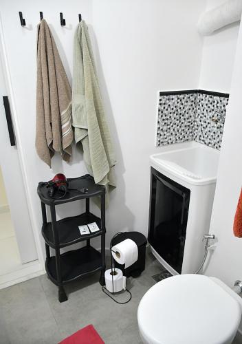 uma casa de banho com WC e uma televisão num quarto em ACONCHEGANTE APTO COPACABANA no Rio de Janeiro