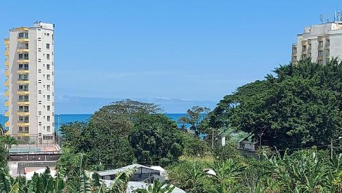 two tall buildings with trees and the ocean in the background at Hotel Almond Beach in Tonsupa