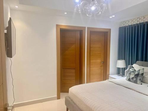 a bedroom with a bed and a flat screen tv at 1BR Luxury apartment Pool, gym, rooftop Santo Domingo in Santo Domingo