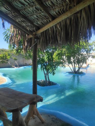 uma mesa de piquenique junto à água num resort em Anacardium em Canoa Quebrada