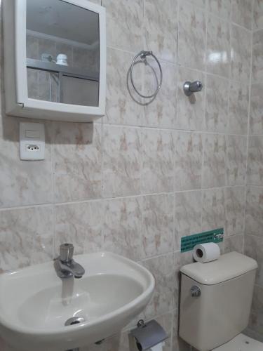a bathroom with a sink and a toilet and a mirror at Apeninos Suites Basicas in Sao Paulo