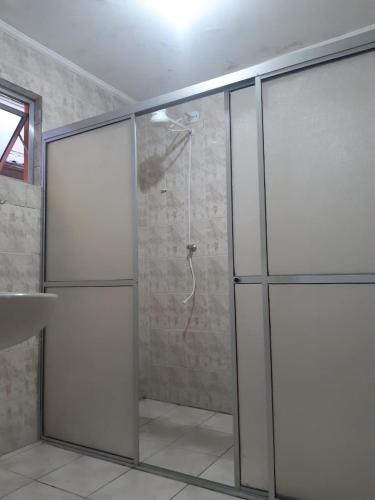 a bathroom with a shower with a glass door at Apeninos Suites Basicas in Sao Paulo