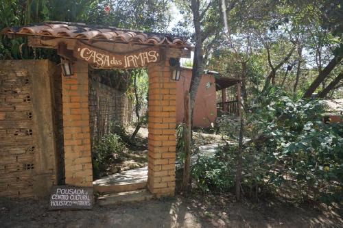 een toegang tot een bakstenen gebouw met een bord bij Casa das Irmãs - Só Mulheres - Women Only in Vale do Capao