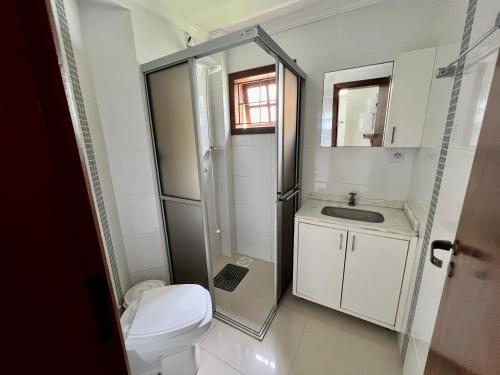 a small bathroom with a toilet and a sink at Casa a 50 M do Mar Para Recarregar as Energias in Bombinhas