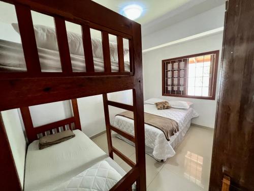 a bedroom with two bunk beds and a window at Casa a 50 M do Mar Para Recarregar as Energias in Bombinhas