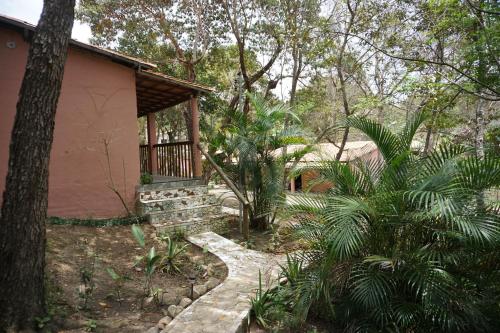 a house with a walkway next to a tree at Casa das Irmãs - Só Mulheres - Women Only in Vale do Capao