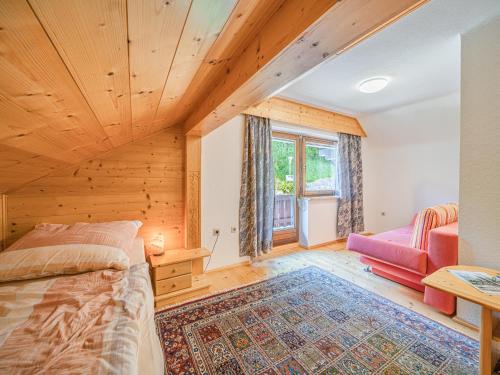 um quarto com uma cama e uma cadeira num quarto em Ferienhaus Rieder em Hopfgarten im Brixental