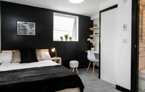 a bedroom with a bed and a black wall at Room in a Shared House, Dean Street, CV2 in London