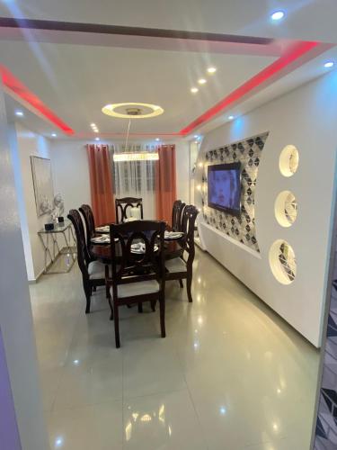 a dining room with a table and chairs and a tv at VIP Home in Santiago de los Caballeros