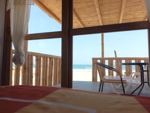 a bedroom with a bed and a view of the beach at Bungalows Sol y Mar in Canoas De Punta Sal