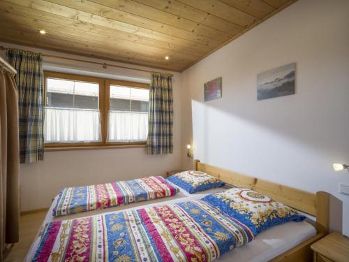 two beds in a bedroom with a wooden ceiling at Apartment Erich Brixen in Brixen im Thale
